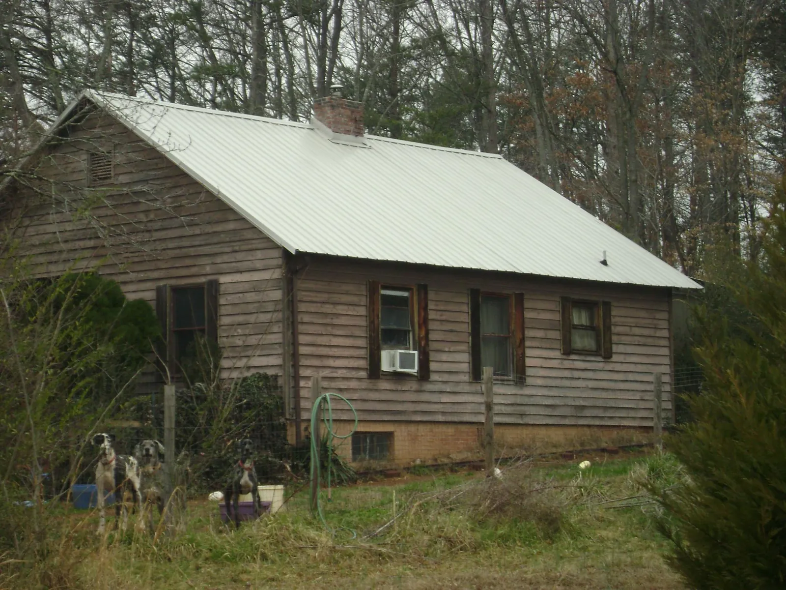 White metal roof on an old wood sided farmhouse, from a Metal Roof Installation job in Cummings